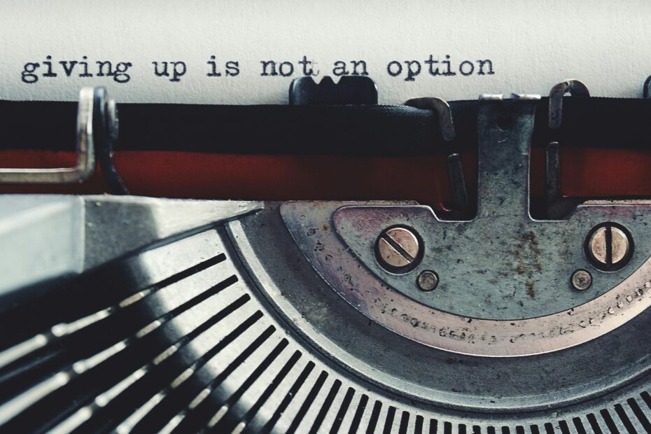 Close-up of a vintage typewriter typing 'giving up is not an option.'